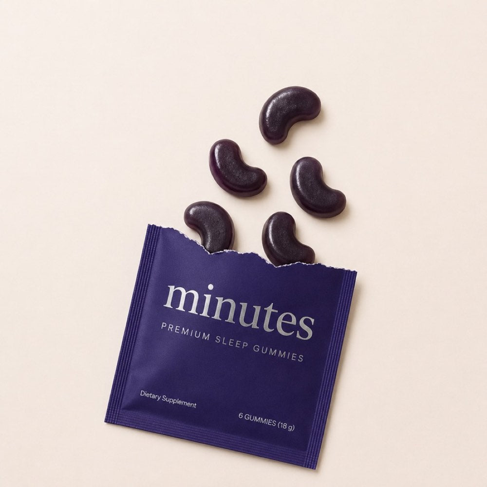 An open Minutes sachet with dark purple blackberry gummies spilling out