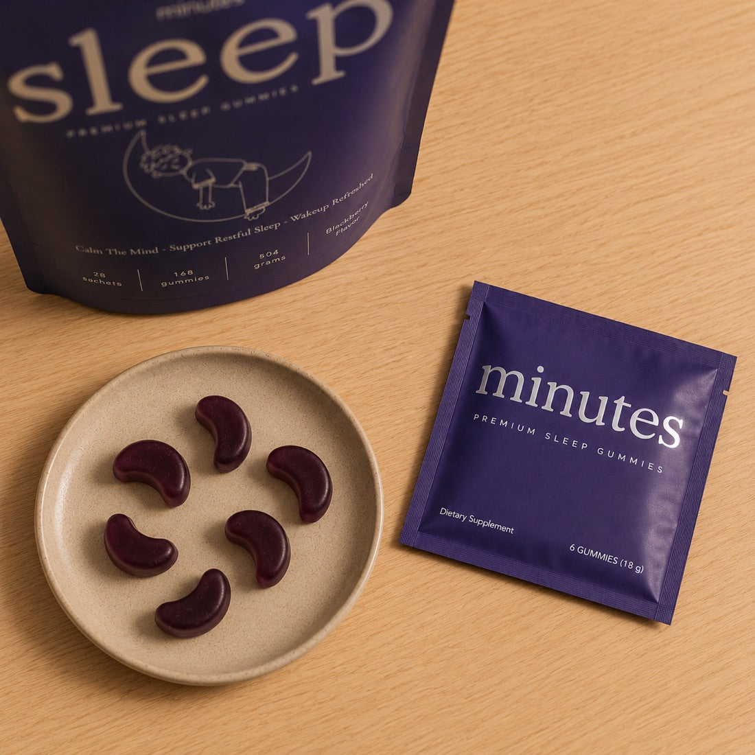 The Minutes bag, a sachet, and six blackberry gummies on a plate
